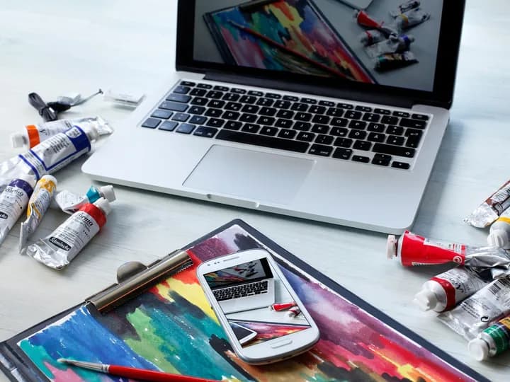 Un ordinateur et une tablette entourés de matériel de création graphique