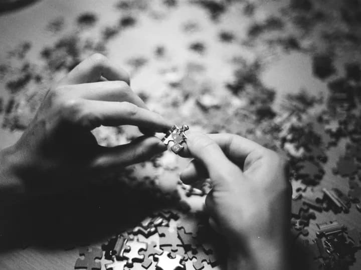 Des mains assemblent les pièces d’un puzzle