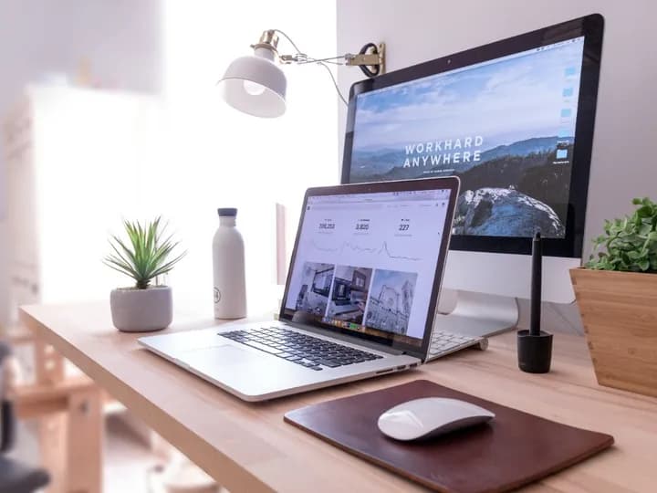 Un ordinateur portable et un grand écran sur un bureau lumineux
