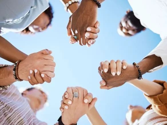 Une collaboration autour de vos objectifs Un groupe de personnes se tient par les mains en cercle