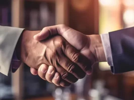 Un accompagnement fondé sur la collaboration Deux personnes se serrent la main dans un cadre professionnel